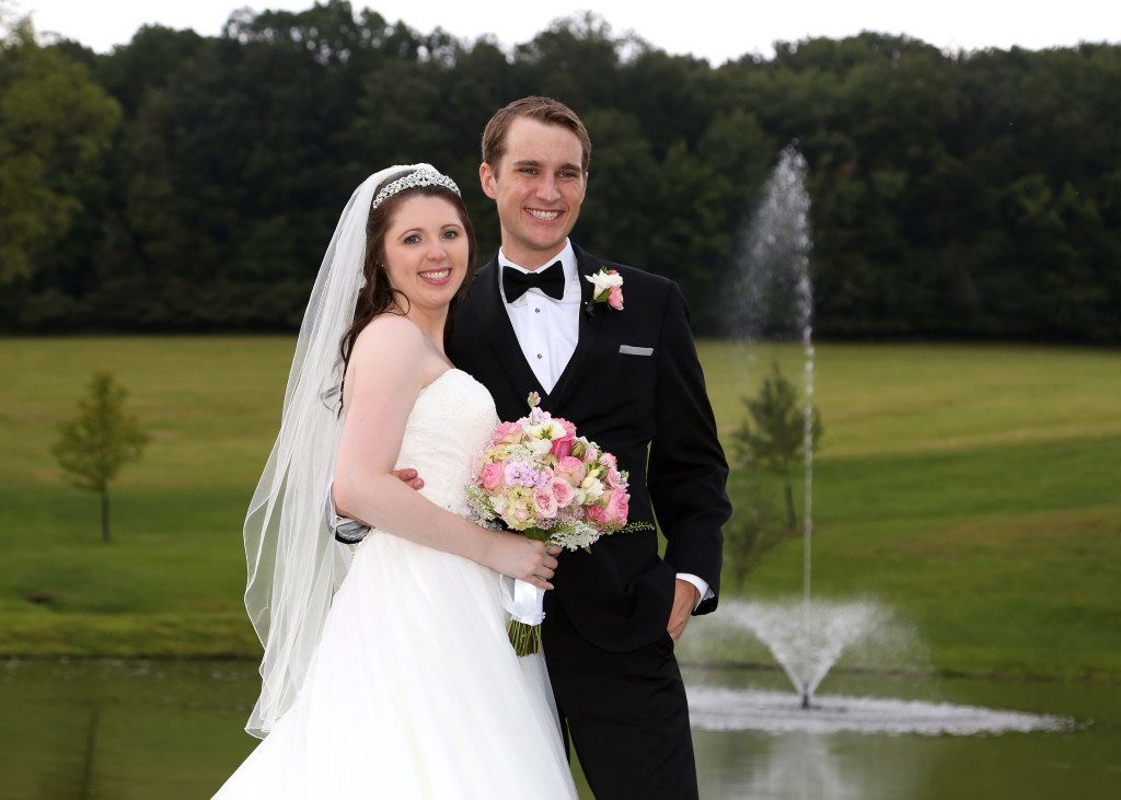 Bride and Groom pose for photograph after wedding ceremony in Maryland by the pond fountain at Morningside Inn country wedding venue in Maryland