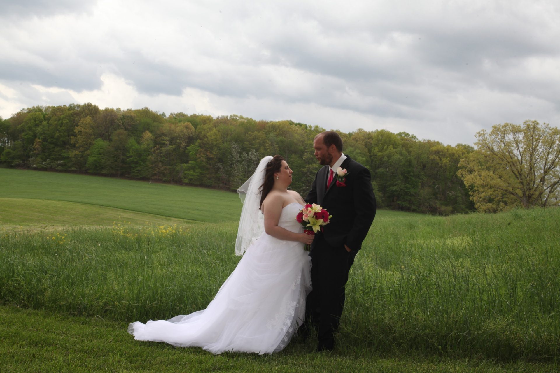 Outside wedding at Morningside Inn, bride and groom pose with rolling hills as backdrop