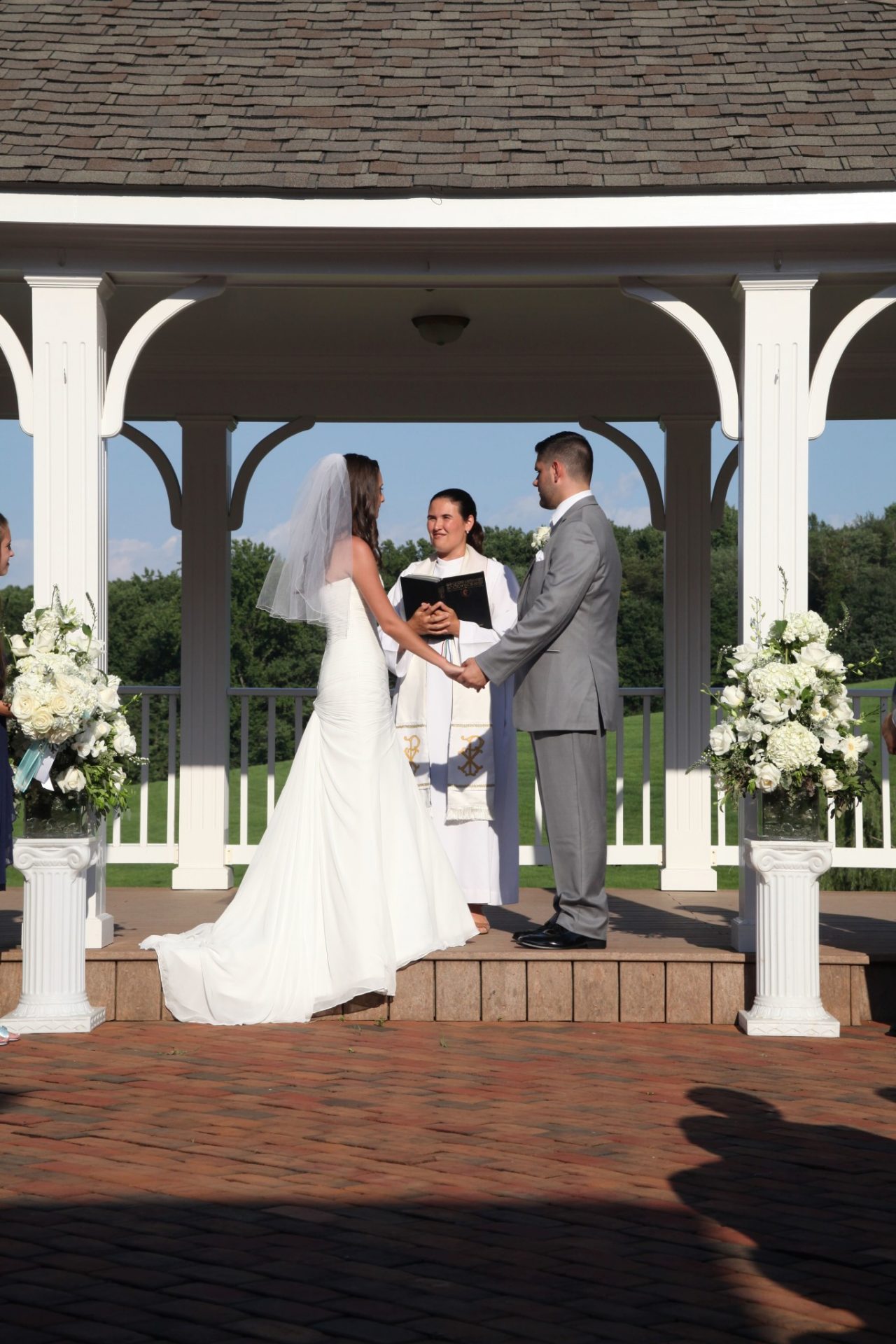 Close up of bride and groom on pavilion during outdoor wedding ceremony