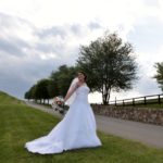 bride in the grass by the stone wall
