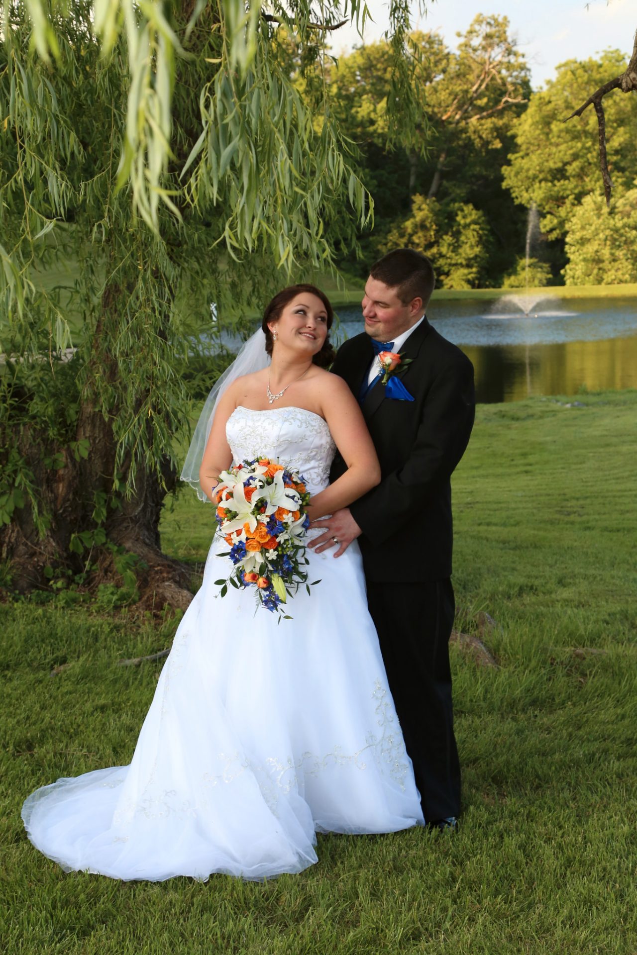 bride and broom pose in front of the old willow tree at morningside inn