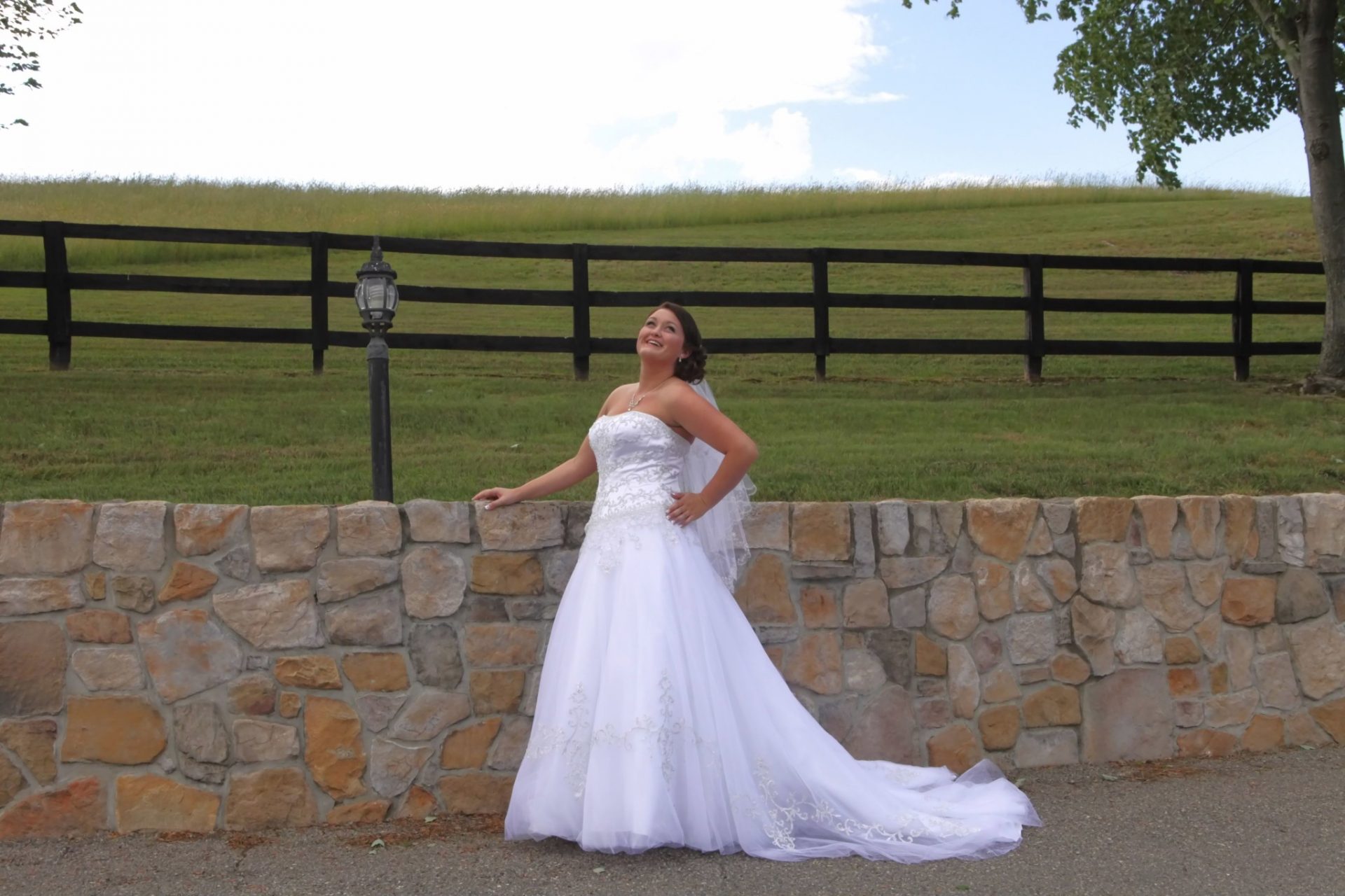 bride posing in front of the stone wall