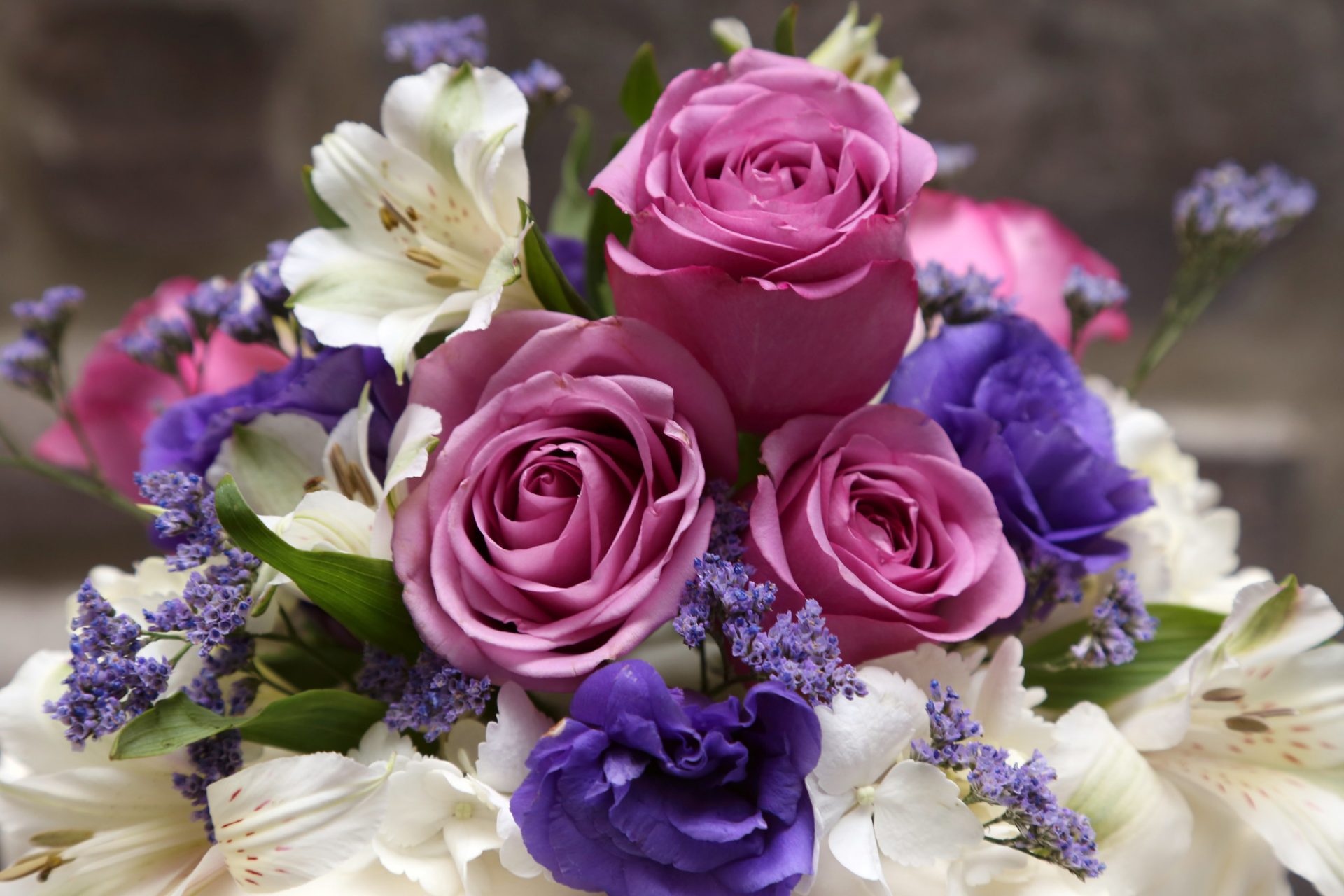 Close up of pink and purple roses used in summer wedding floral arrangement.