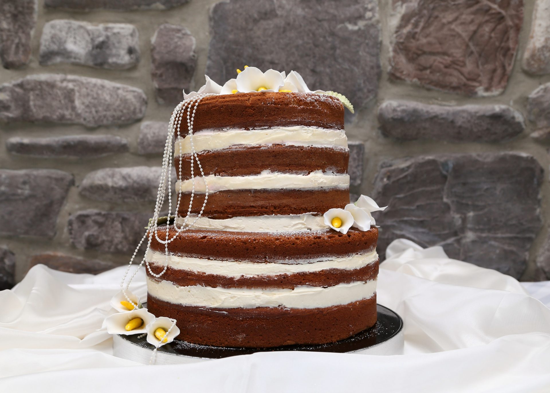 Naked wedding cake topped with flowers