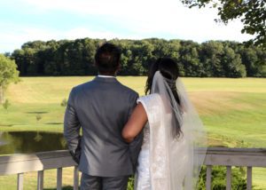 Bride and Groom enjoy view on deck leading to large brick patio