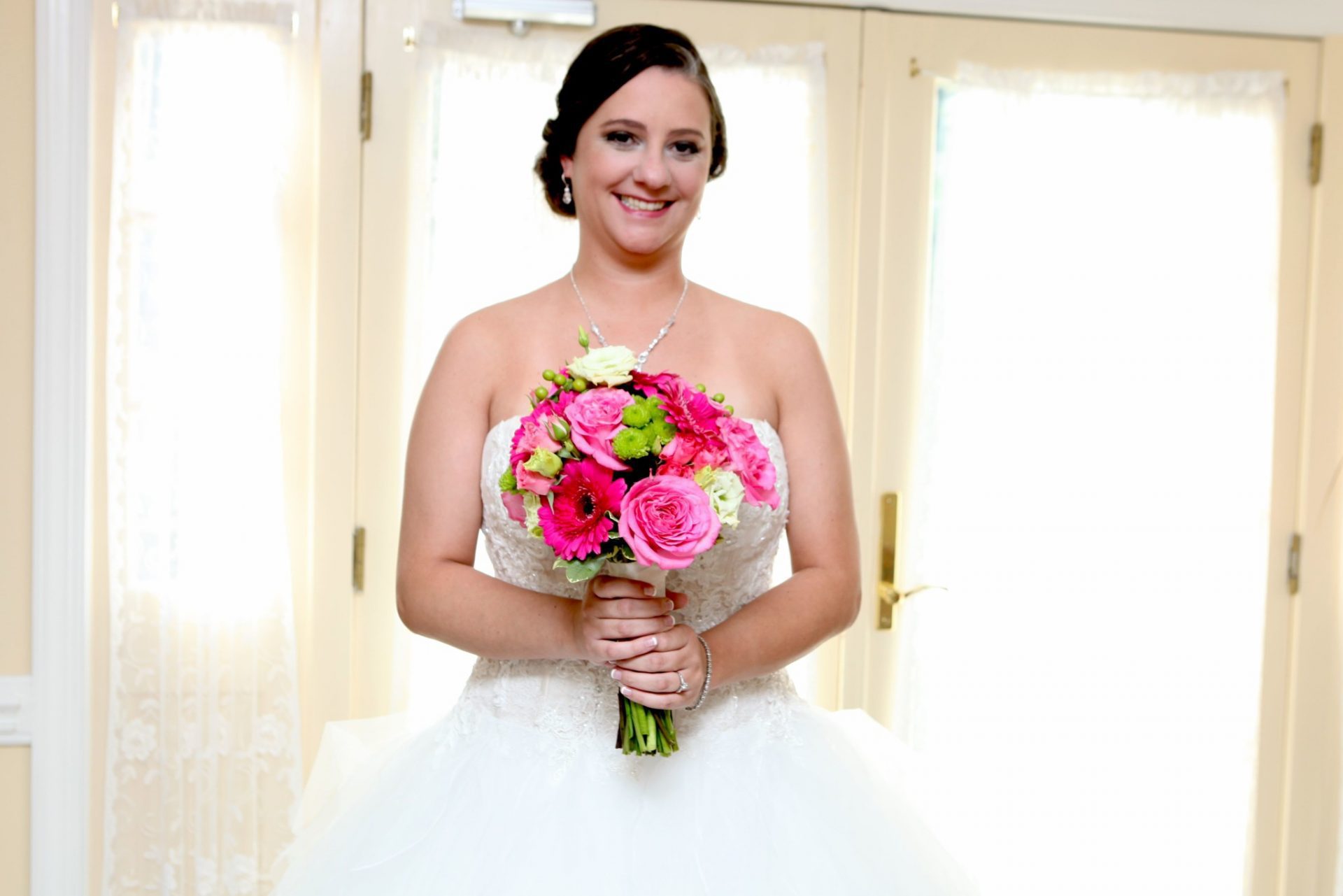 Bride poses by window in bride's room