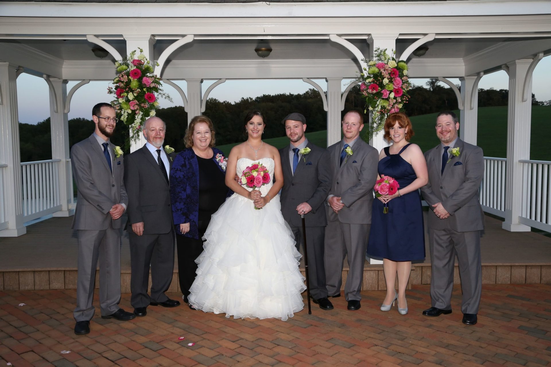 Wedding party on brick patio in front of wedding pavilion
