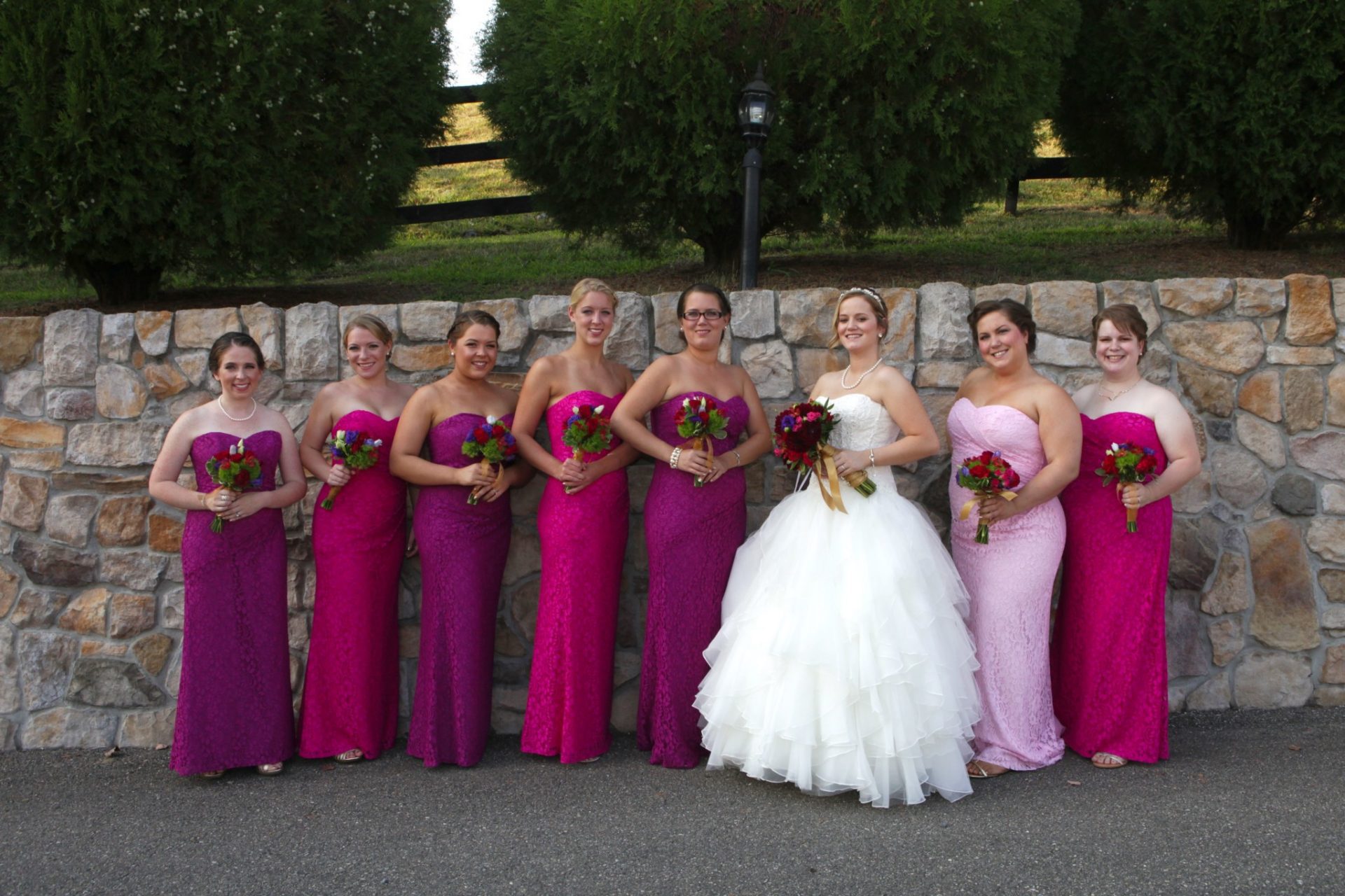 Bridal party poses by stone wall in front of Morningside Inn wedding venue in Frederick MD