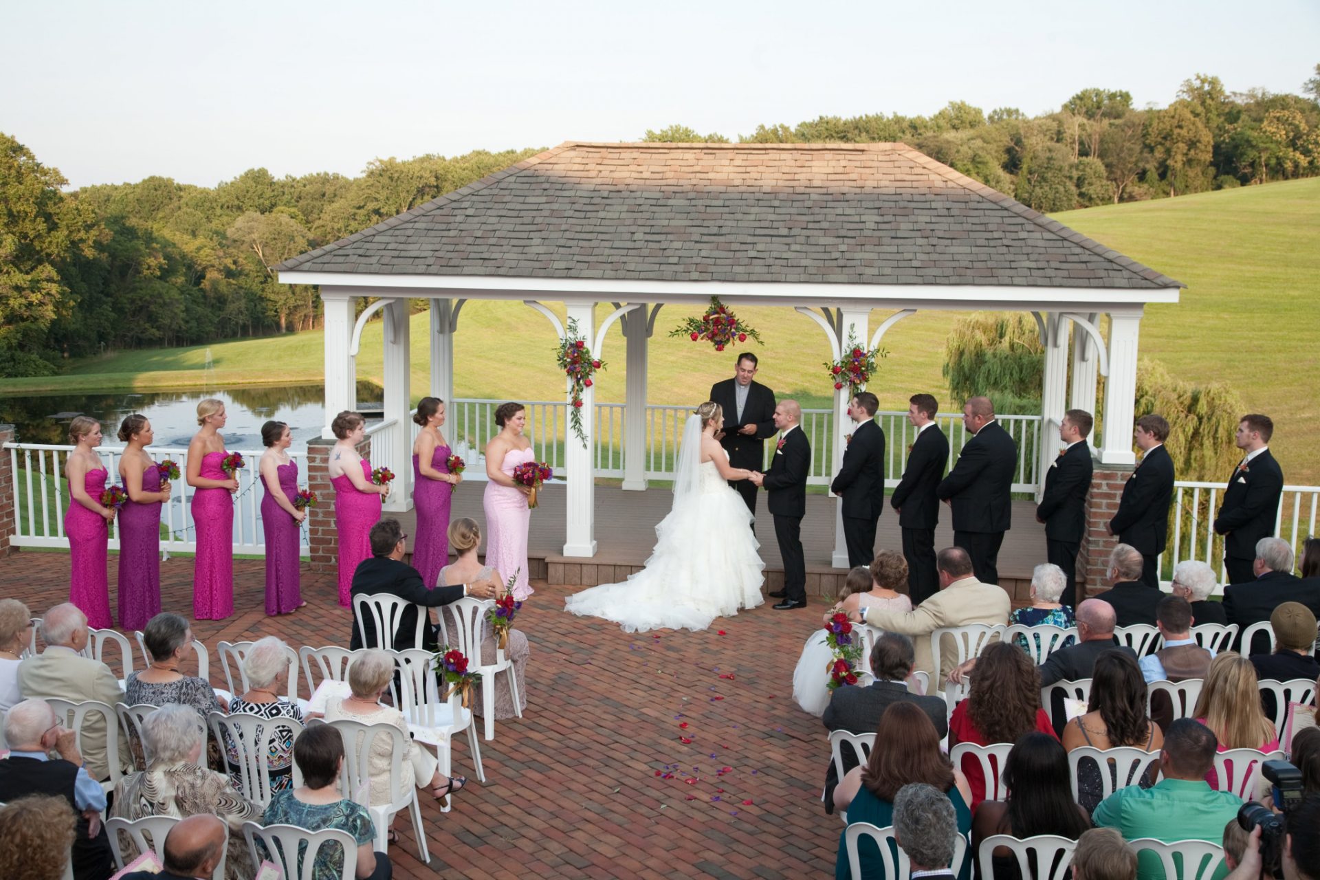 Bride and Groom exchange vows on pavilion during outdoor wedding ceremony