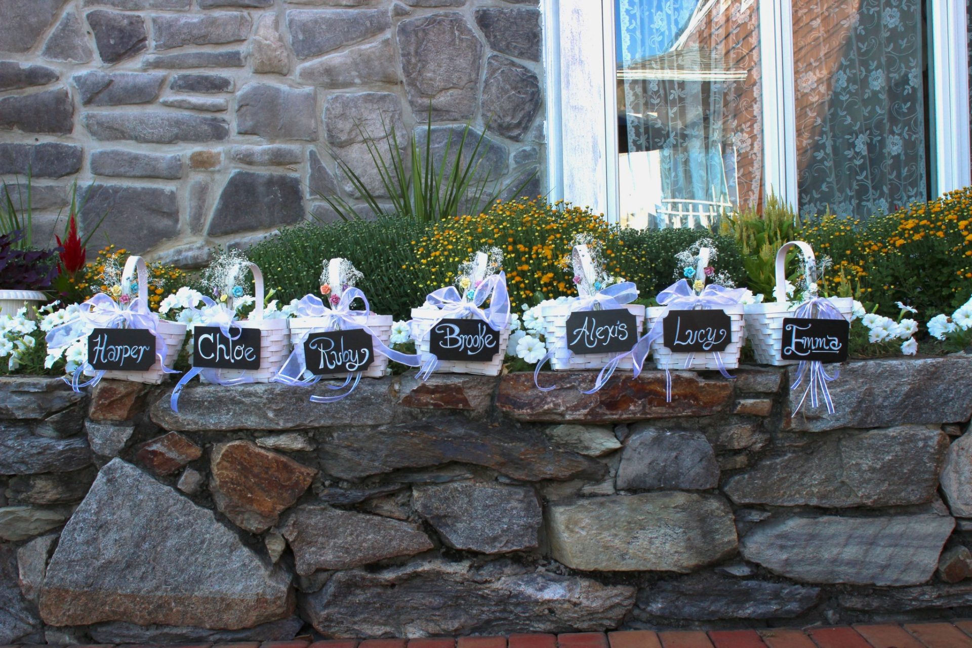 Flower girl baskets sit on stone wall before wedding