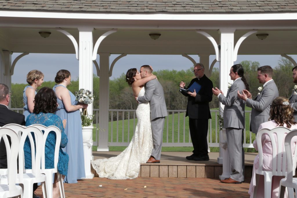 Kissing after April country wedding outdoor wedding ceremony