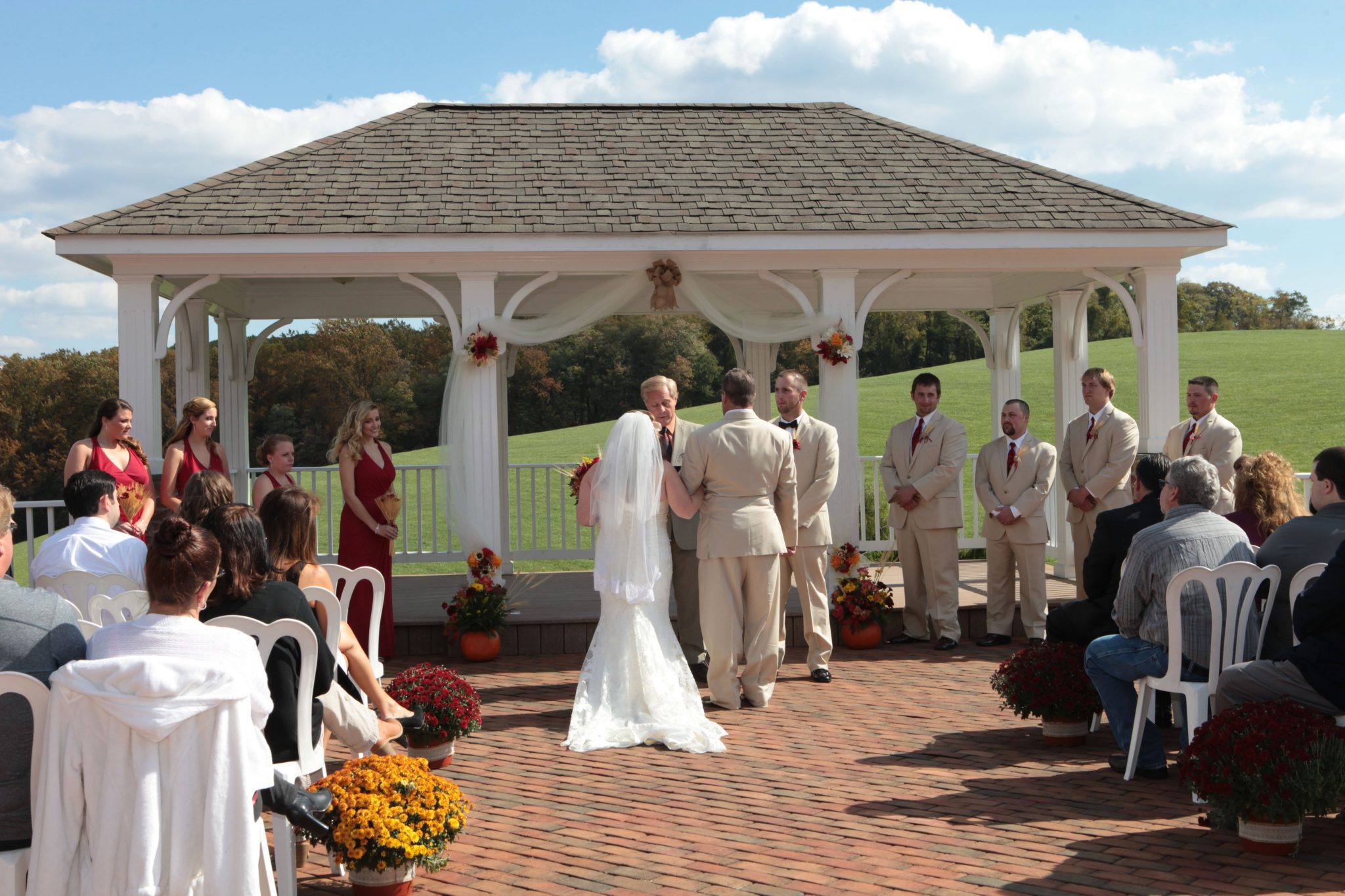 Outdoor wedding ceremony is held on covered pavilion