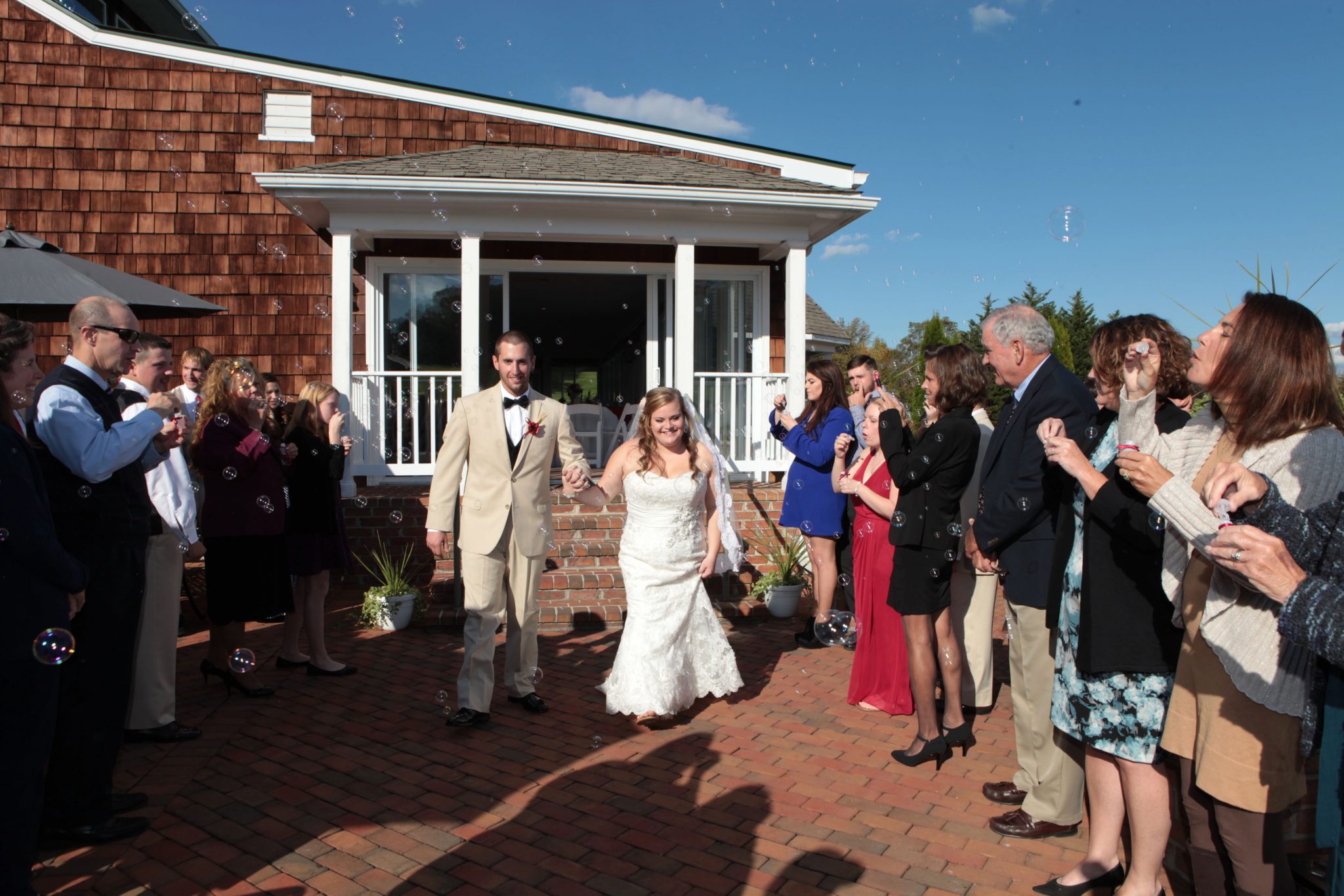 Couple walks from outdoor wedding pavilion after vows