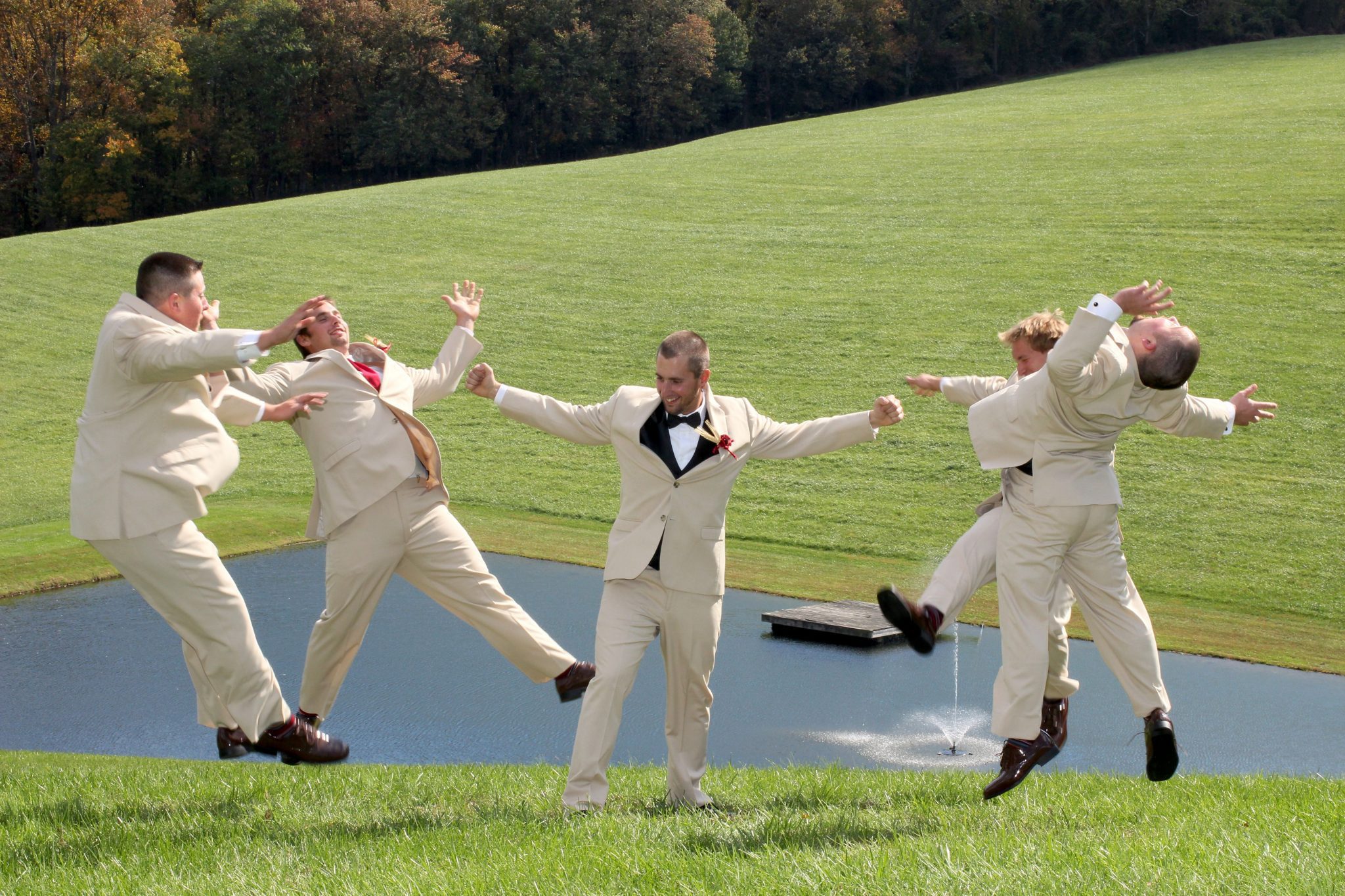 Groomsmen pose by pond on back lawn of private estate near Hagerstown Maryland
