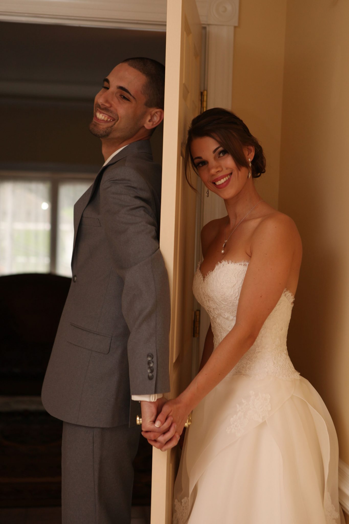Bride and groom stay on opposite sides of door before wedding ceremony in this fun photo.
