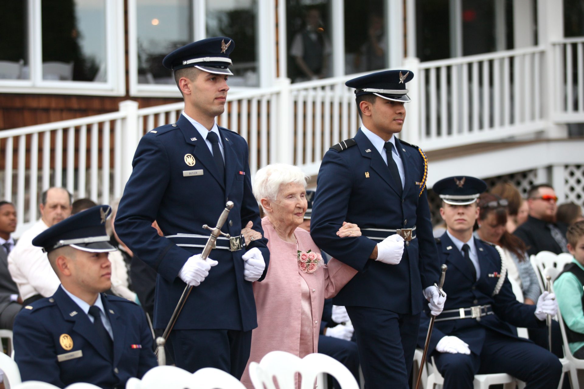 Grandmother escorted by military during tea party theme wedding