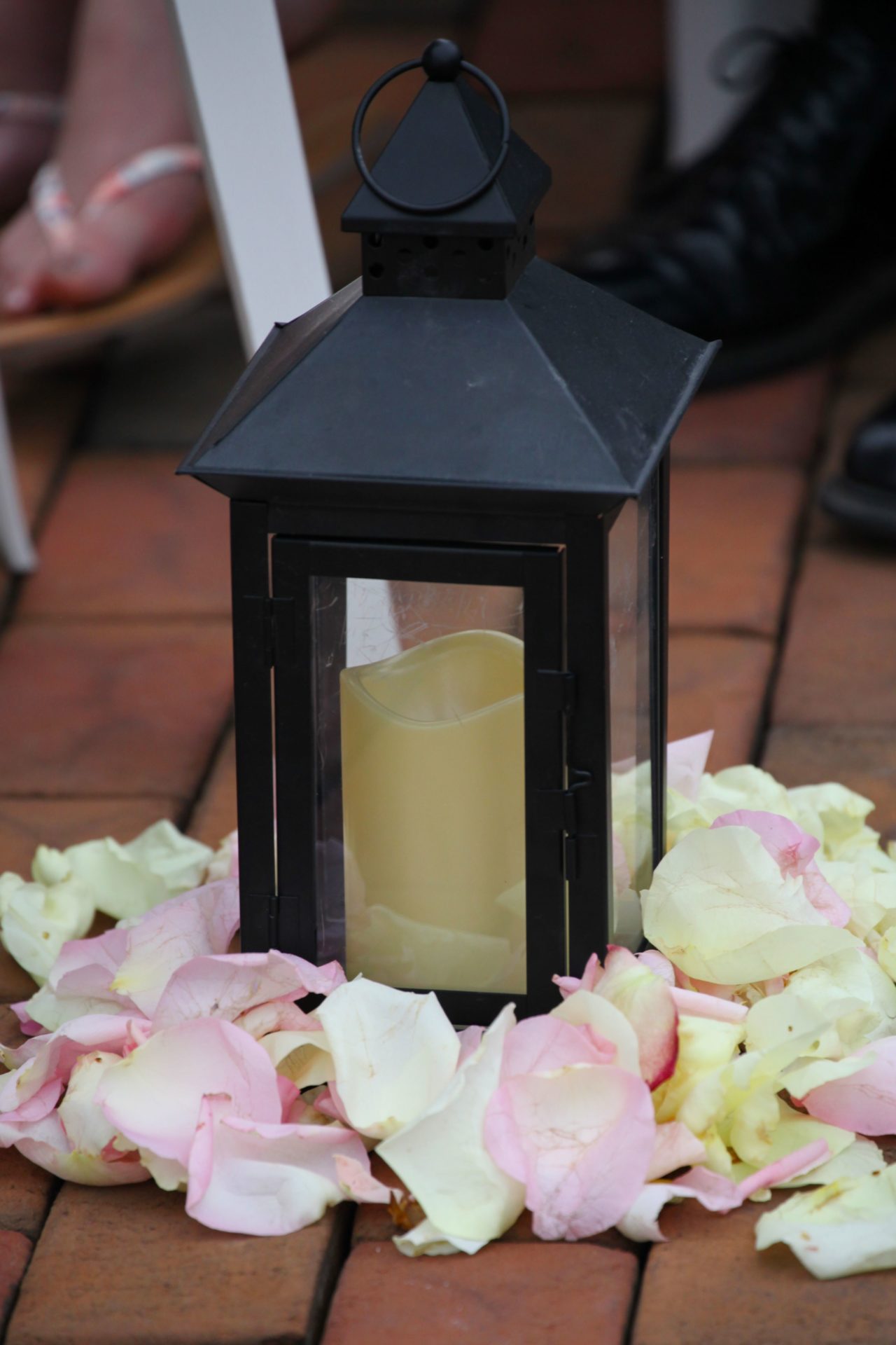 Rose petals around candle to decorate wedding ceremony aisle