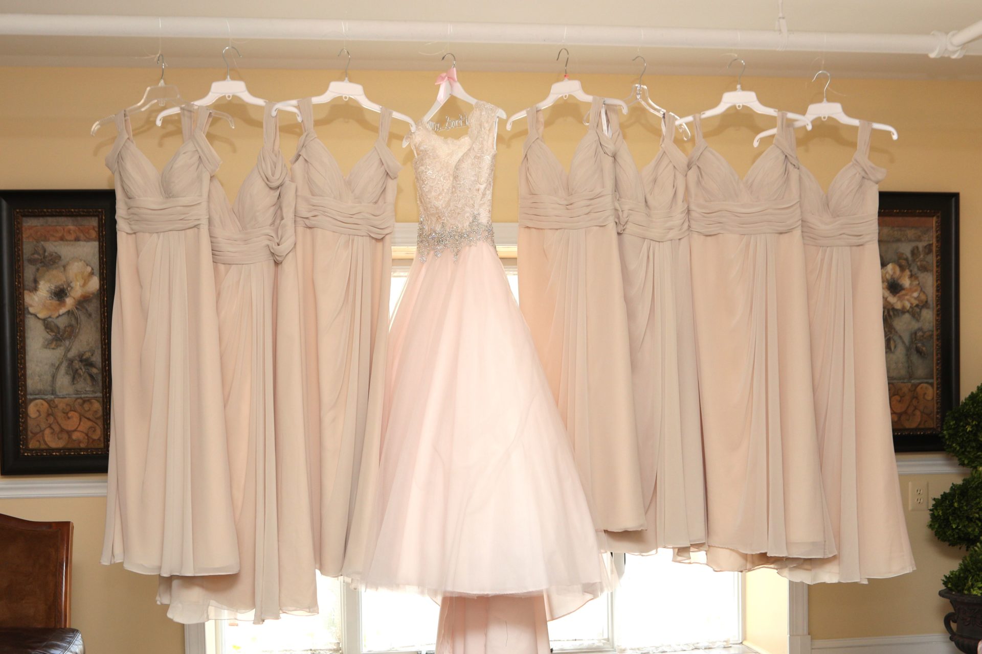 Wedding dress and bride's maid dress hang in the brides room at Morningside Inn wedding venue in Frederick Maryland