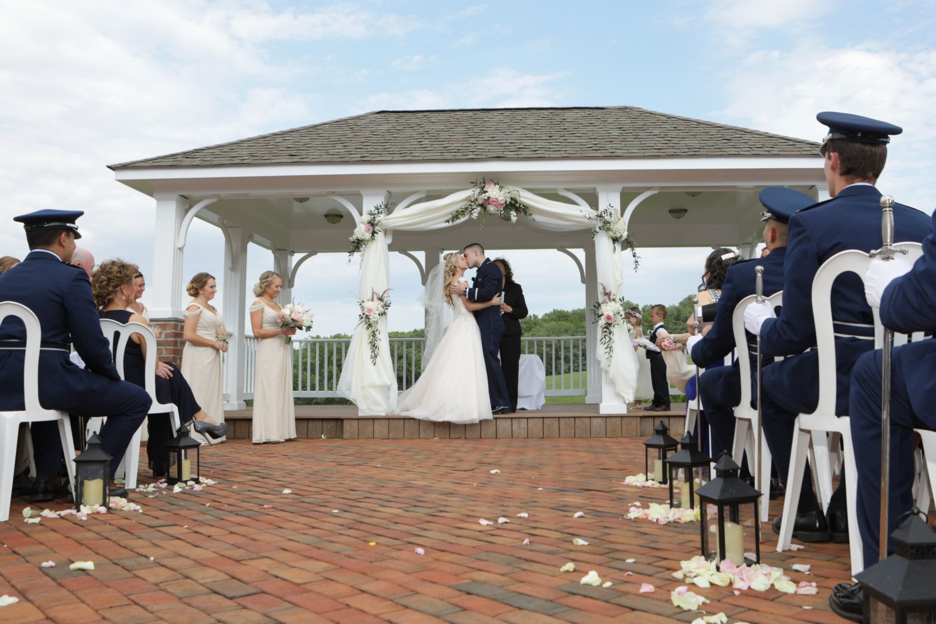 Bride and groom kiss on pavilion after outdoor wedding ceremony in Maryland