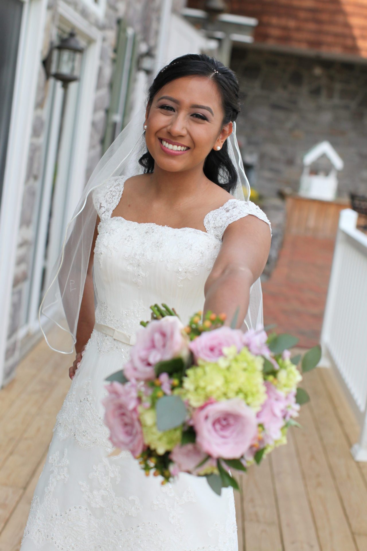 Bride poses with bouquet on back deck at Morningside Inn