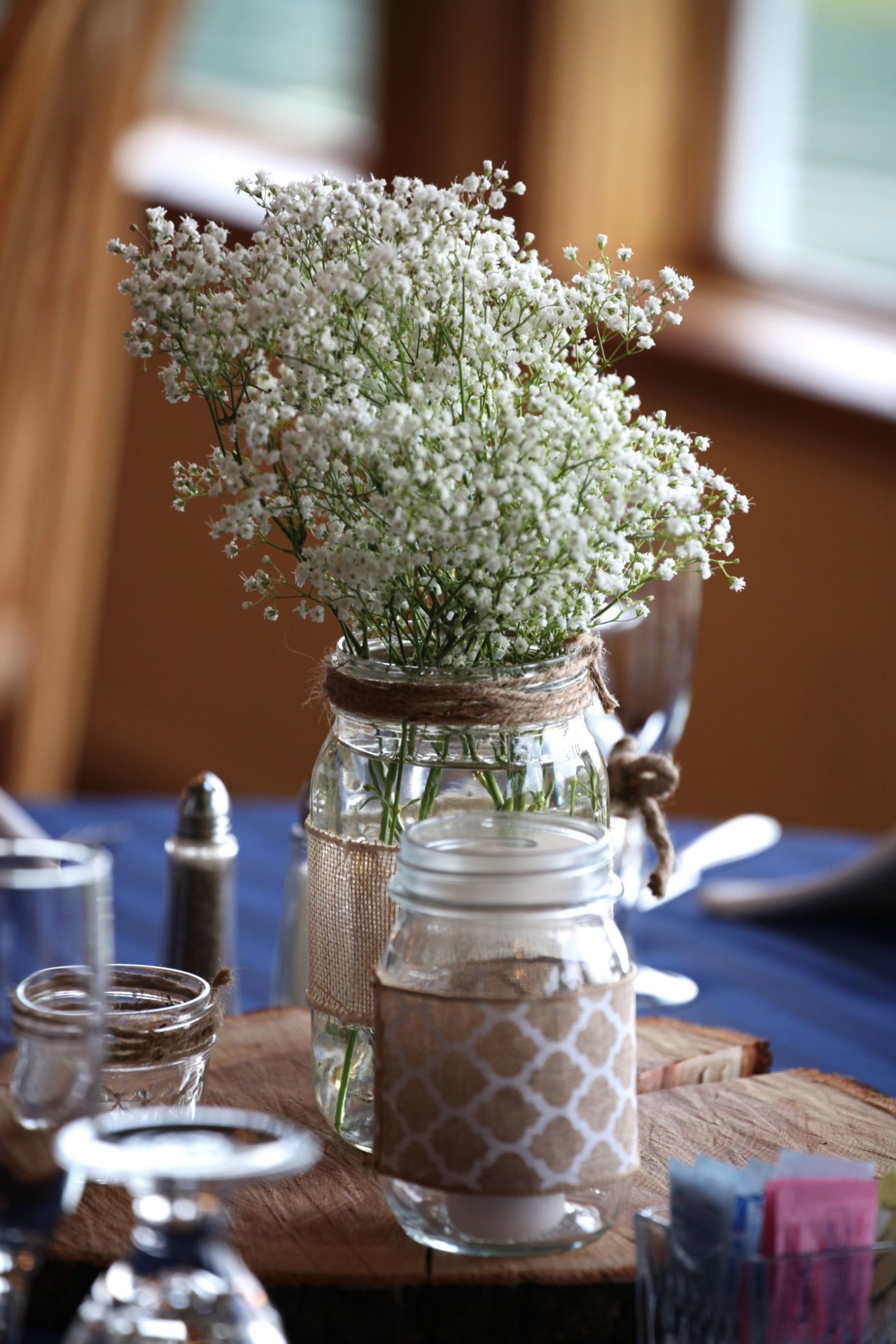 Simple rustic wedding centerpiece with glass jar and baby's breath flowers