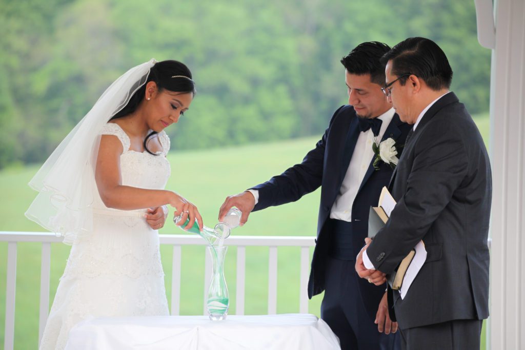 Bride and groom pour unity sand during outdoor wedding ceremony at Morningside Inn wedding venue Frederick MD