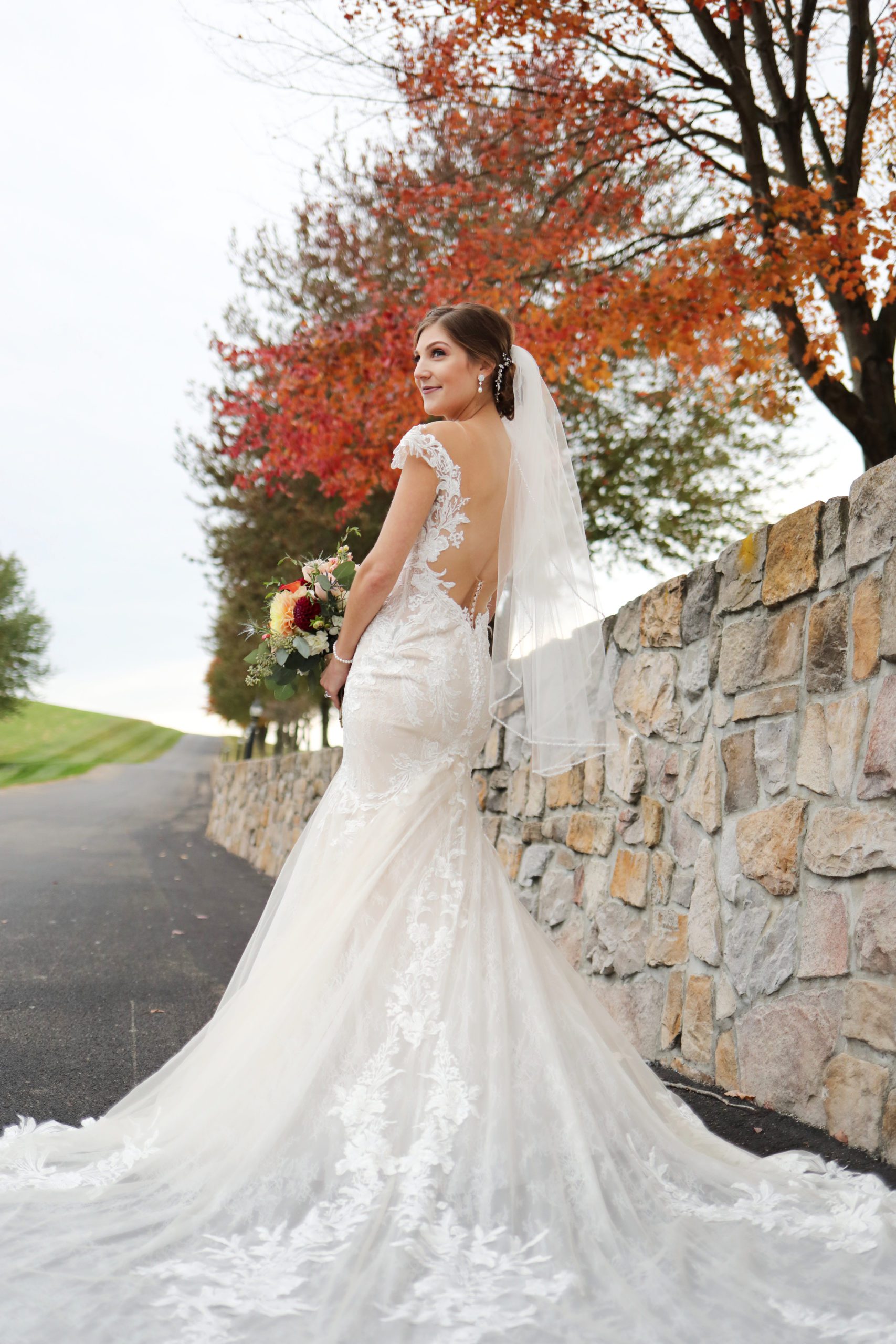 Bride by wedding venue wall Bride stands by stone wall at Morningside Inn Wedding venue in frederick private estate